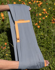 einzelner AQUA Loop in "ocean mit orangenem Ripsband", wird von zwei Händen gehalten.