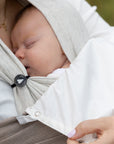 Nahaufnahme, wie ein Baby in den Loops schäft und der Sonnenschutz an den Loops befestigt ist