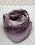 Musselin-Schal in "lila-glitzer", liegt auf hellem Hintergrund