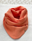 Musselin-Schal in "orange", liegt auf hellem Hintergrund