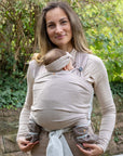Frau trägt Baby in den Loops, das Baby trägt die Softshellschuhe