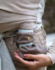 Nahaufnahme - Babyfüße in braunen Softshellschuhen, Baby wird dabei in Loops getragen